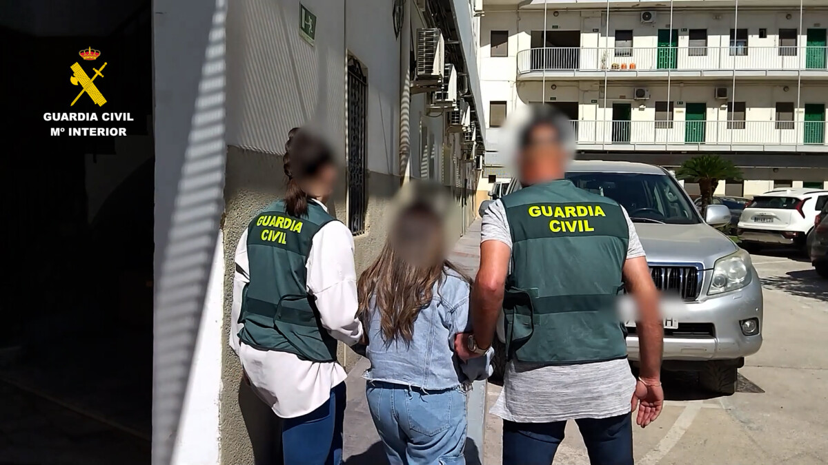 Dos agentes de la Guardia Civil conducen a una de las detenidas